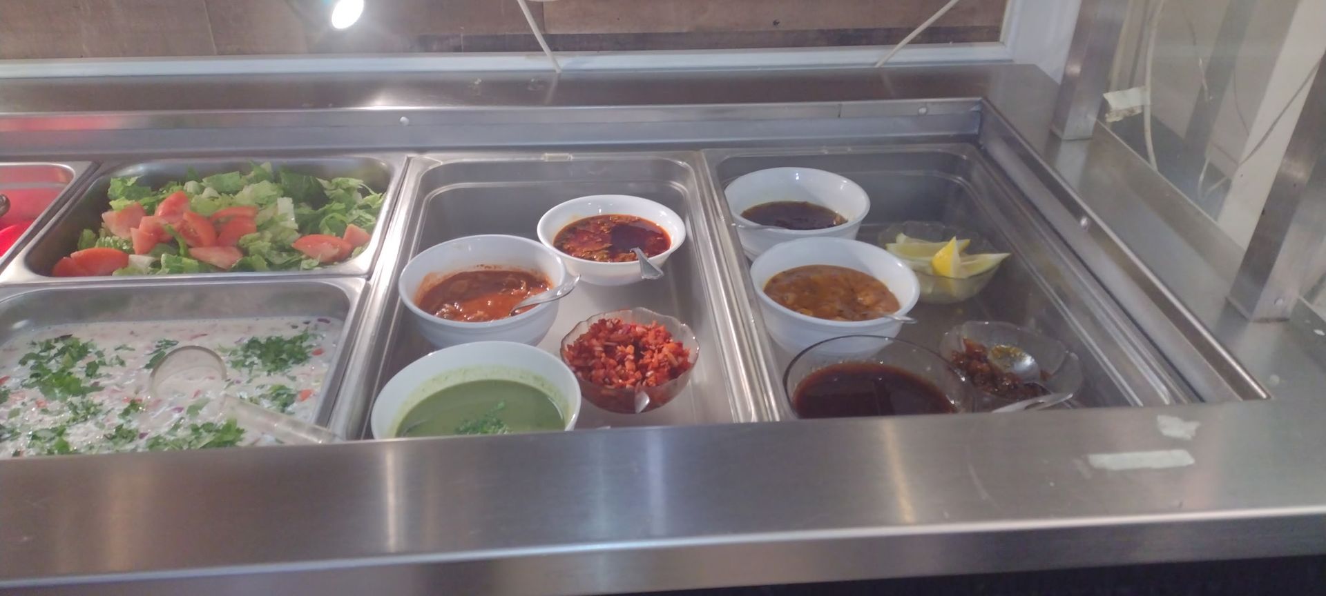 Food bar with various salsas and toppings in a restaurant.