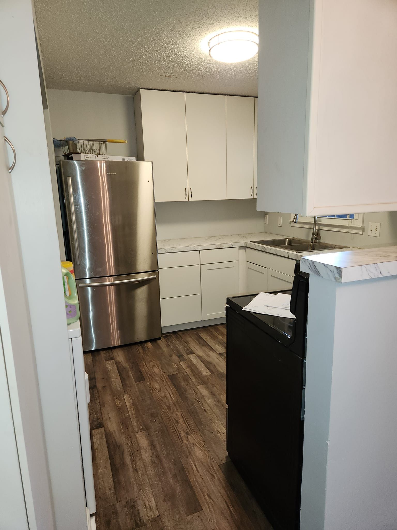 Two men are standing in an empty room with black walls