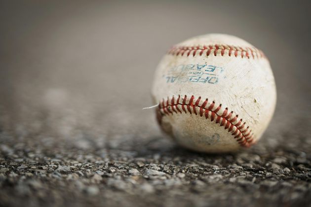 Baseball player sliding into home plate, catcher in front. Blue and gold uniforms, action shot.