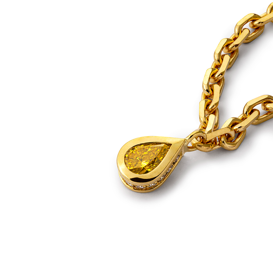 Eine Nahaufnahme eines gelben Diamantanhängers an einer Goldkette