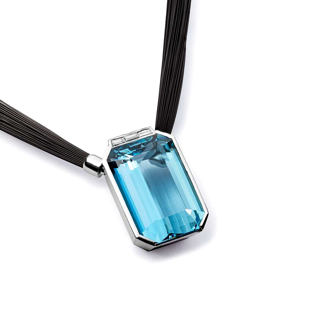 Eine Nahaufnahme einer Halskette mit einem blauen Steinanhänger