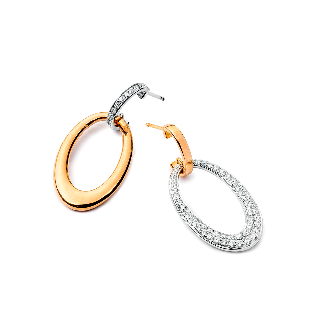 ein Paar Creolen aus Gold und Silber auf weißem Hintergrund