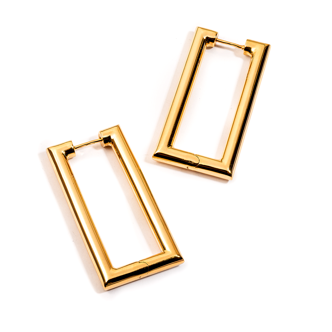 ein Paar goldene rechteckige Creolen auf weißem Hintergrund