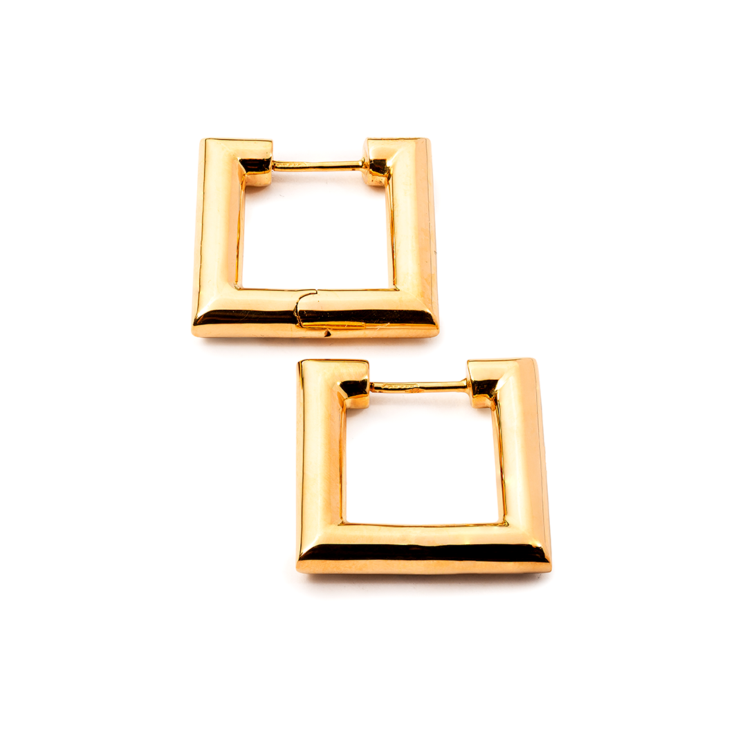 ein Paar goldene quadratische Creolen auf weißem Hintergrund.