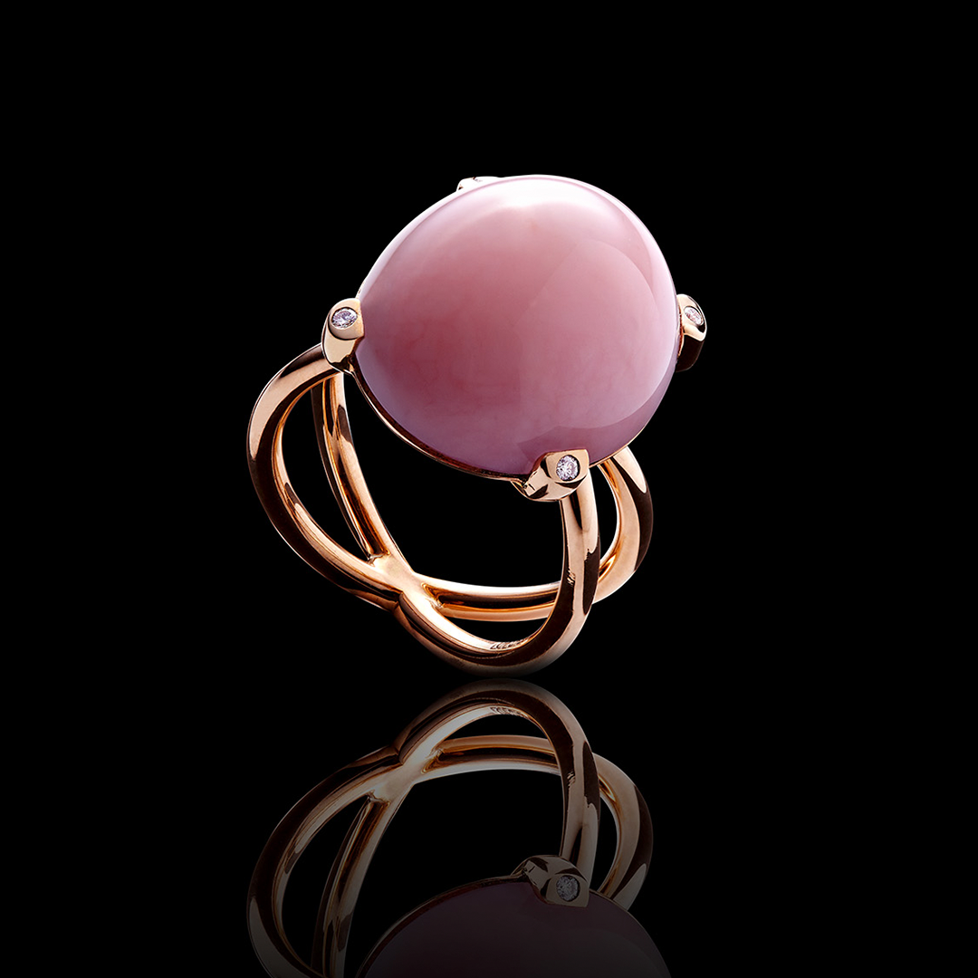 ein goldener Ring mit einem rosa Stein und Diamanten