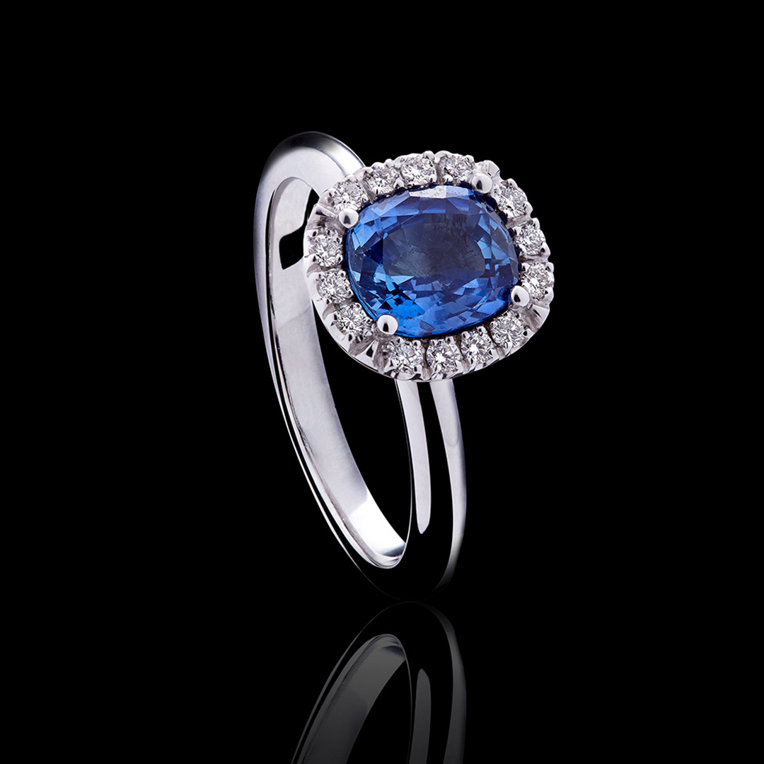 ein Ring mit einem Saphir und Diamanten auf schwarzem Hintergrund