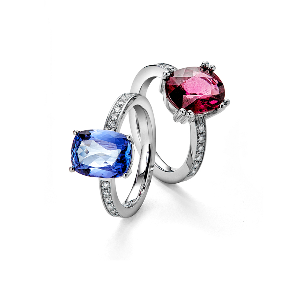 Zwei Ringe mit Steinen darauf auf weißem Hintergrund.