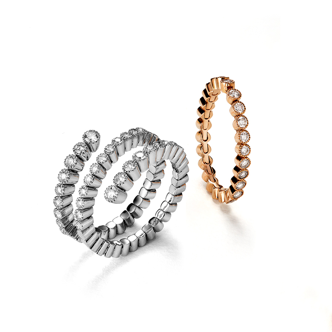 Zwei Ringe sitzen nebeneinander auf einer weißen Fläche.