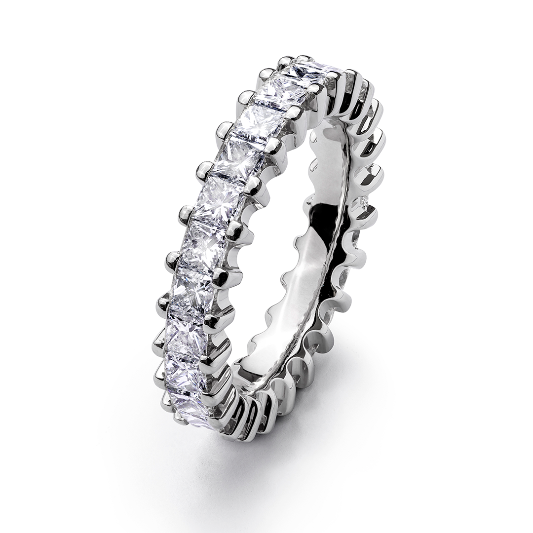 ein silberner Ring mit vielen Diamanten darauf auf weißem Hintergrund.