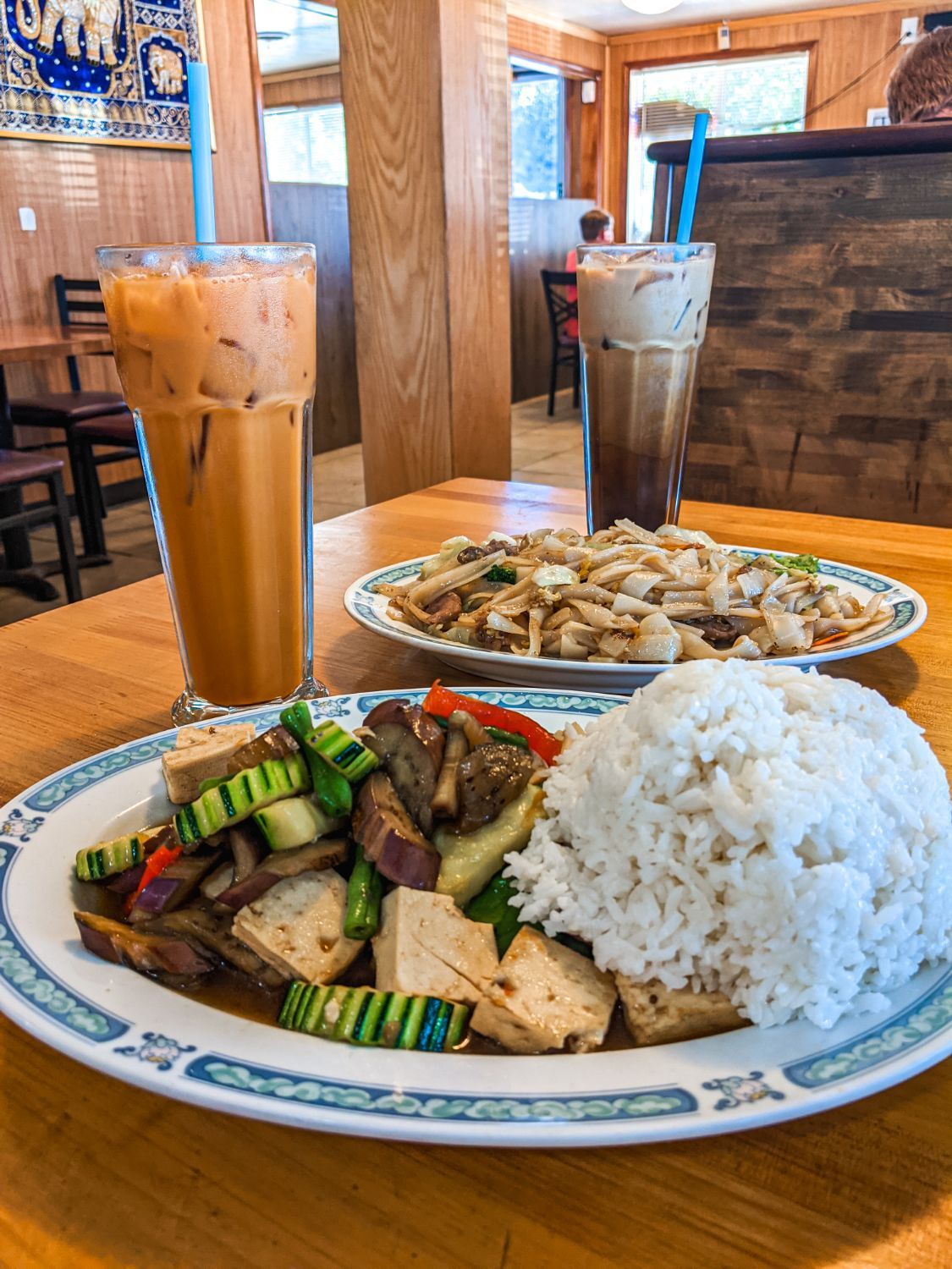 A plate of food with rice and a drink on a table.