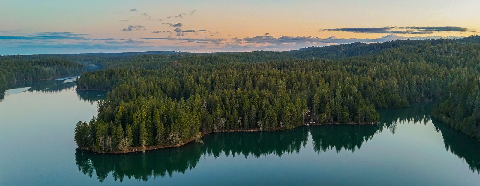 Aerial view Paradise Lakes a forested landscape with a body of water winding through it at dusk.