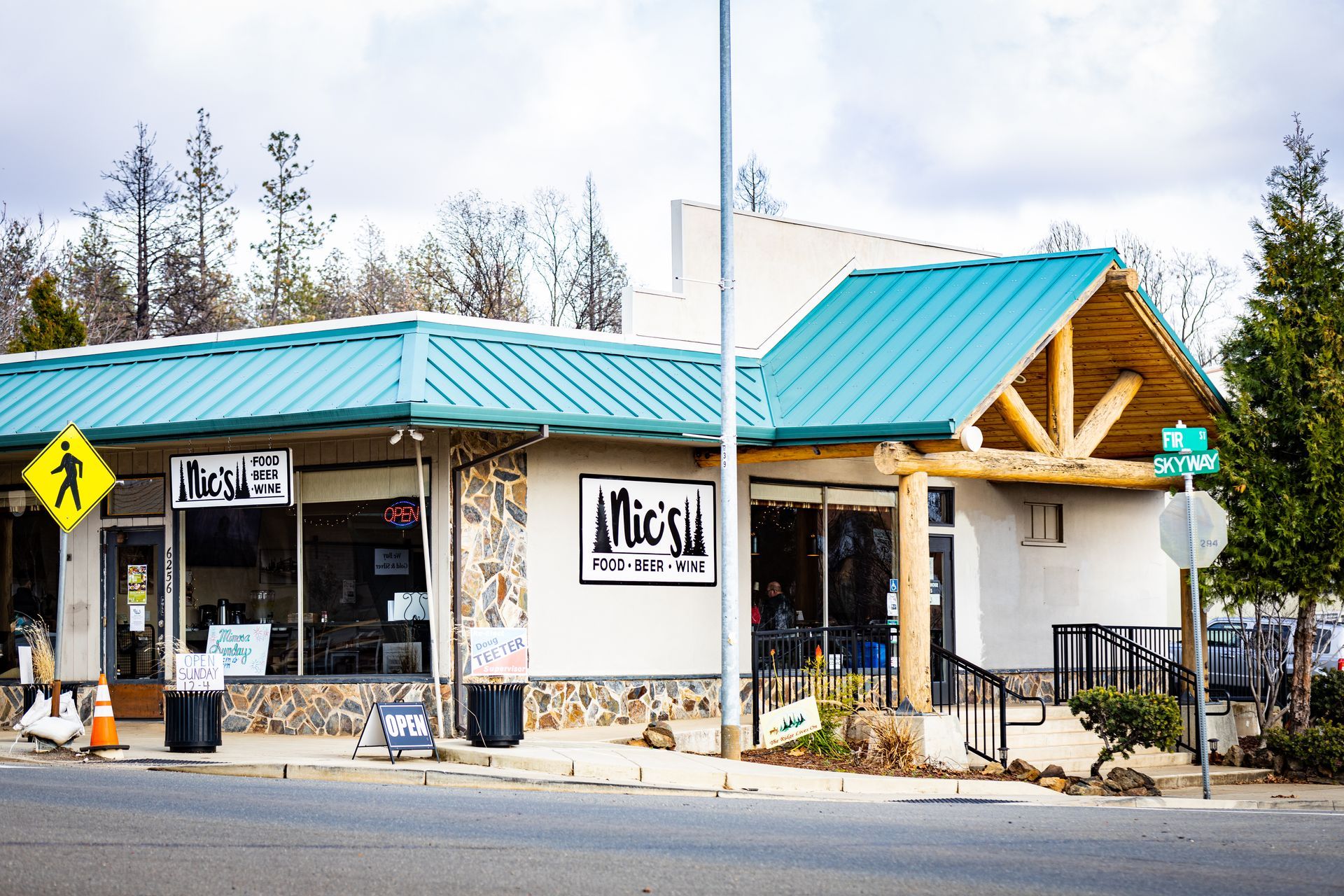 A white building with a green roof and a sign that says Nic's restaurant in Paradise and Magalia, California