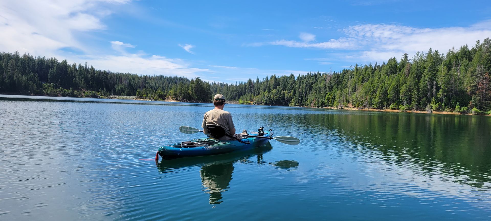 A man is sitting in a kayak on paradise lake.