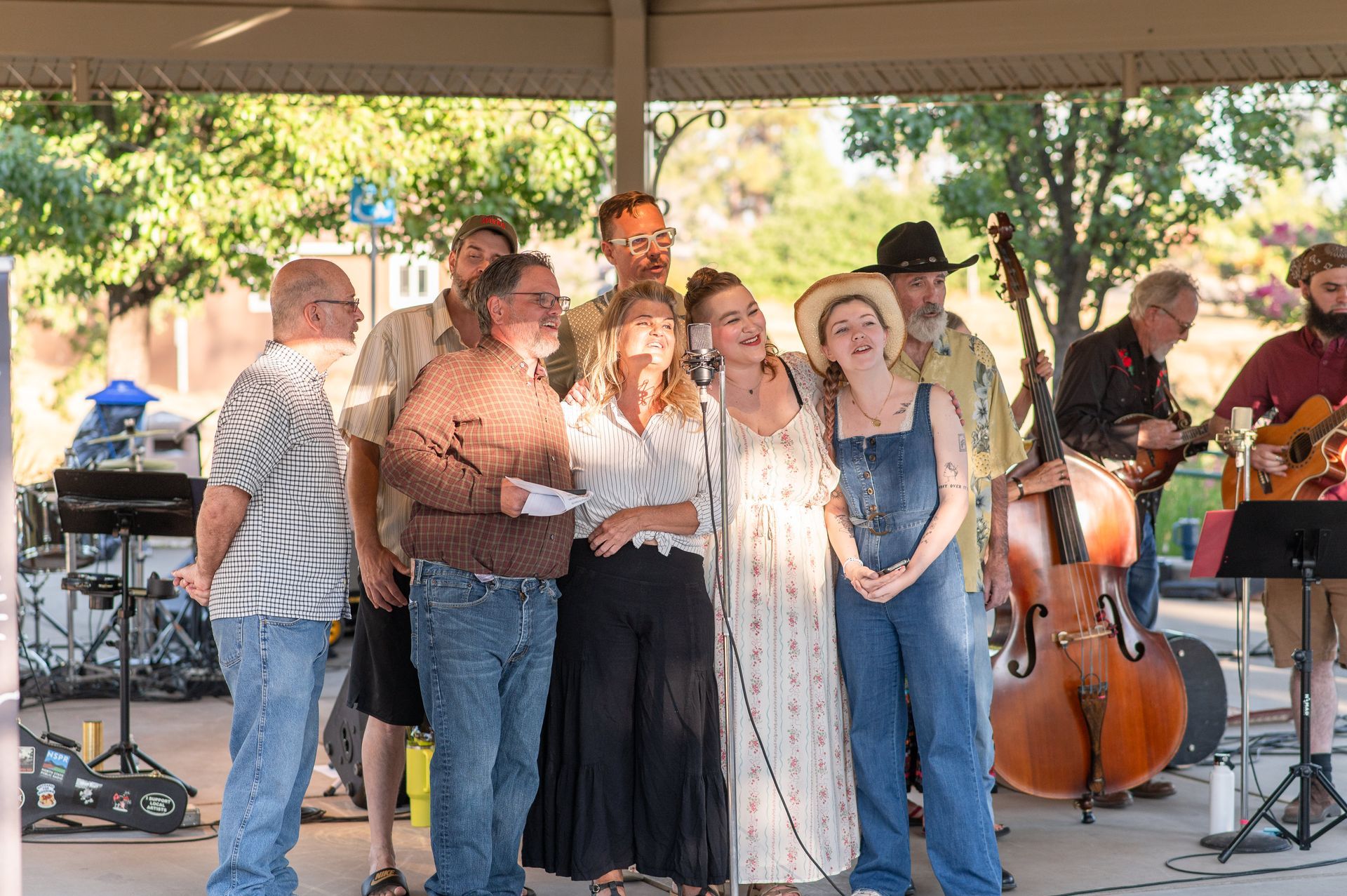 Theatre on the Ridge cast performing a preview of Radioland Paradise.  Actors and actresses singing into a microphone while musicians play instruments