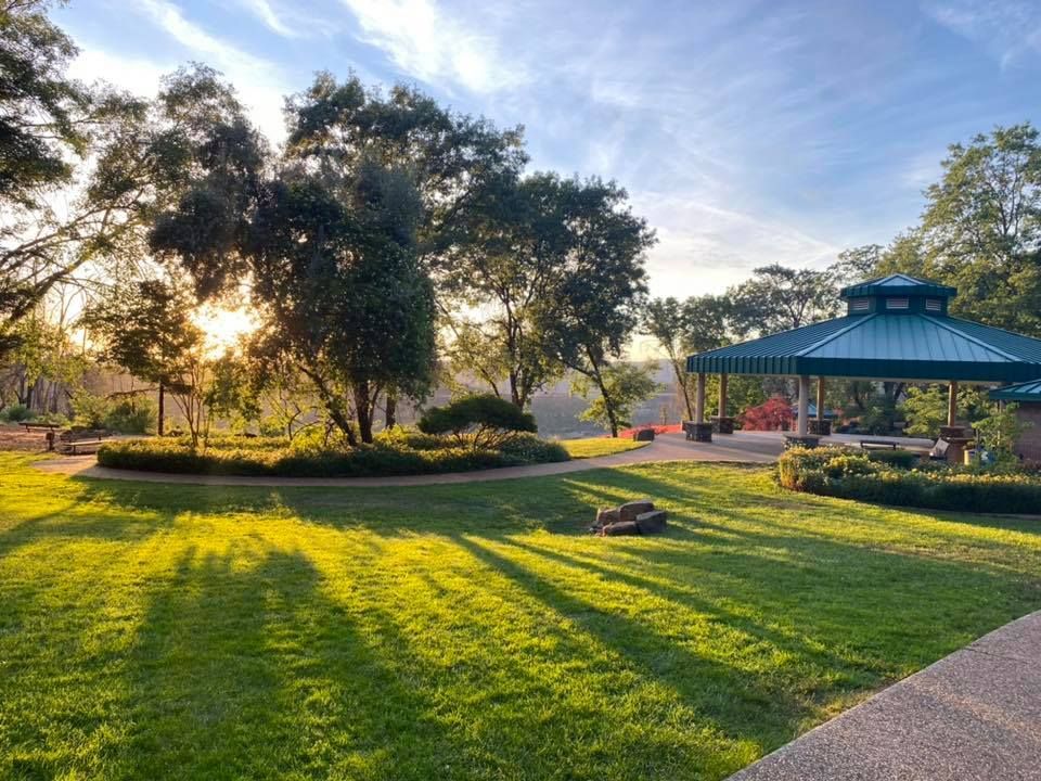 There is a gazebo in the middle of a park surrounded by trees in Paradise and Magalia, California.