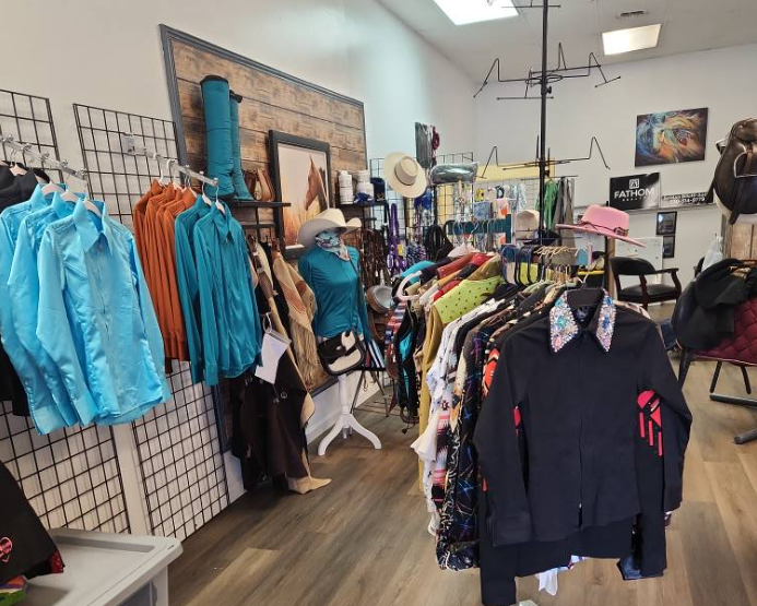 Interior view of The Pickle Pony boutique in Paradise, with neatly arranged racks of equestrian and pickleball apparel, riding gear, and accessories.