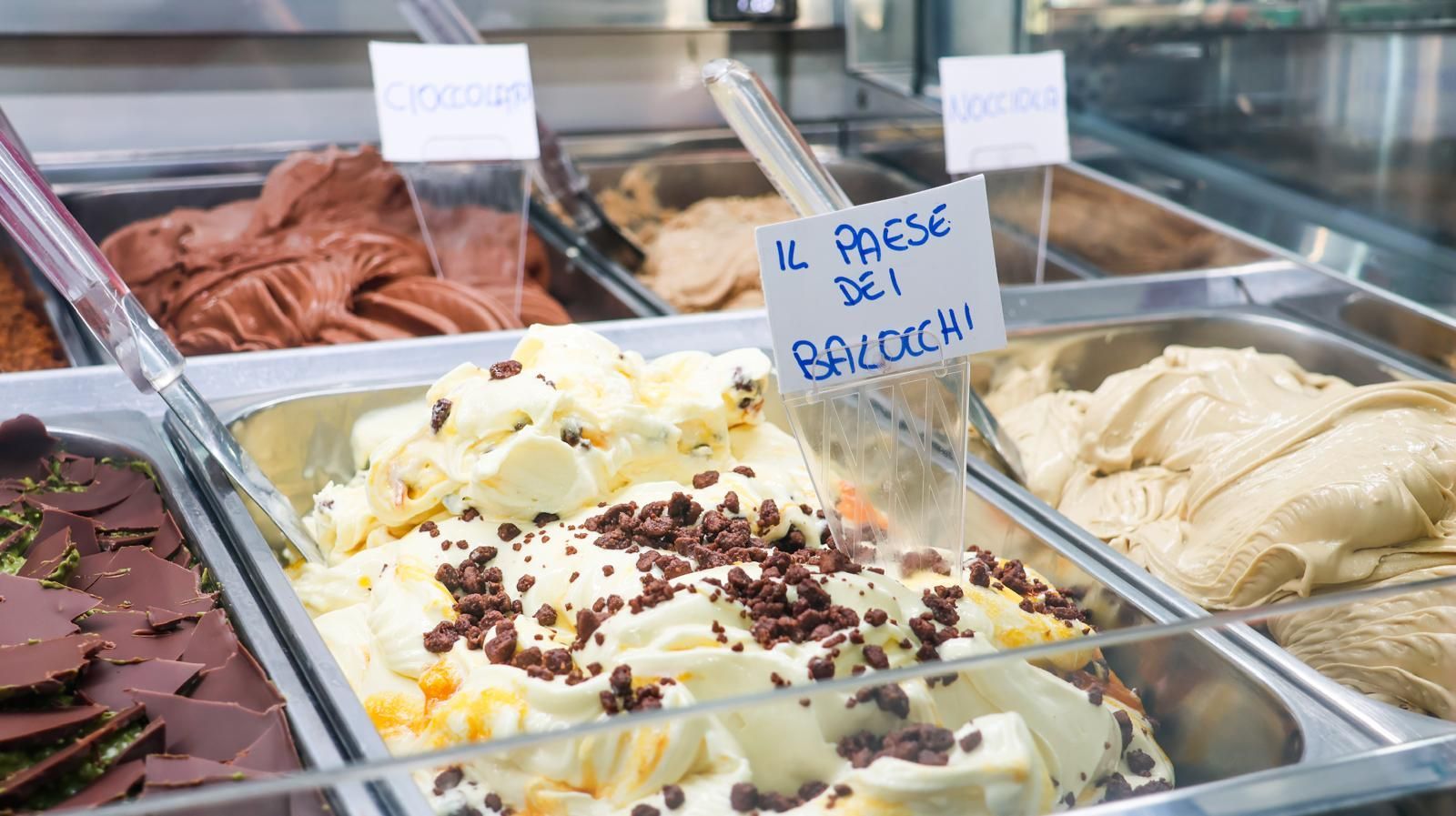 Una vetrina piena di diversi tipi di gelato.
