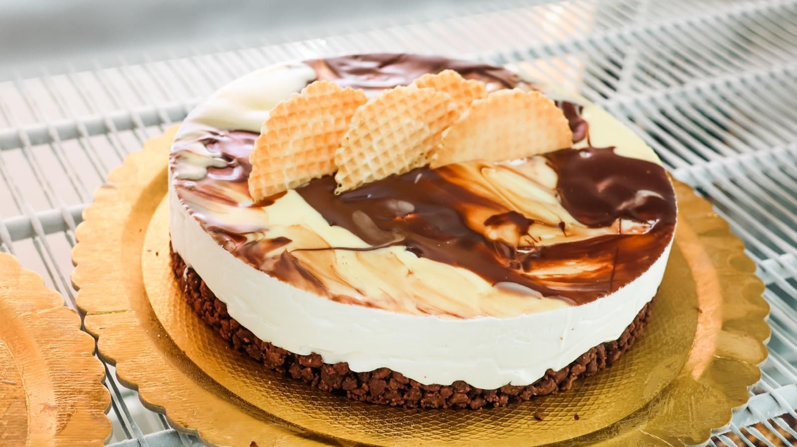 Un primo piano di una torta su un piatto d'oro su una mensola.