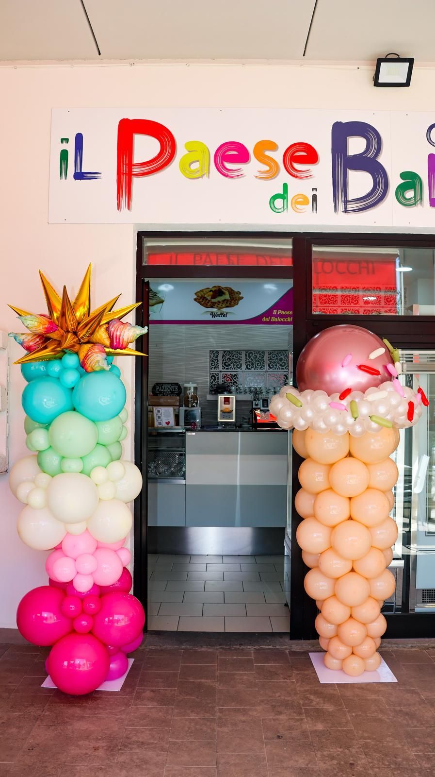 Una vetrina con palloncini e un cartello che dice il paese bar