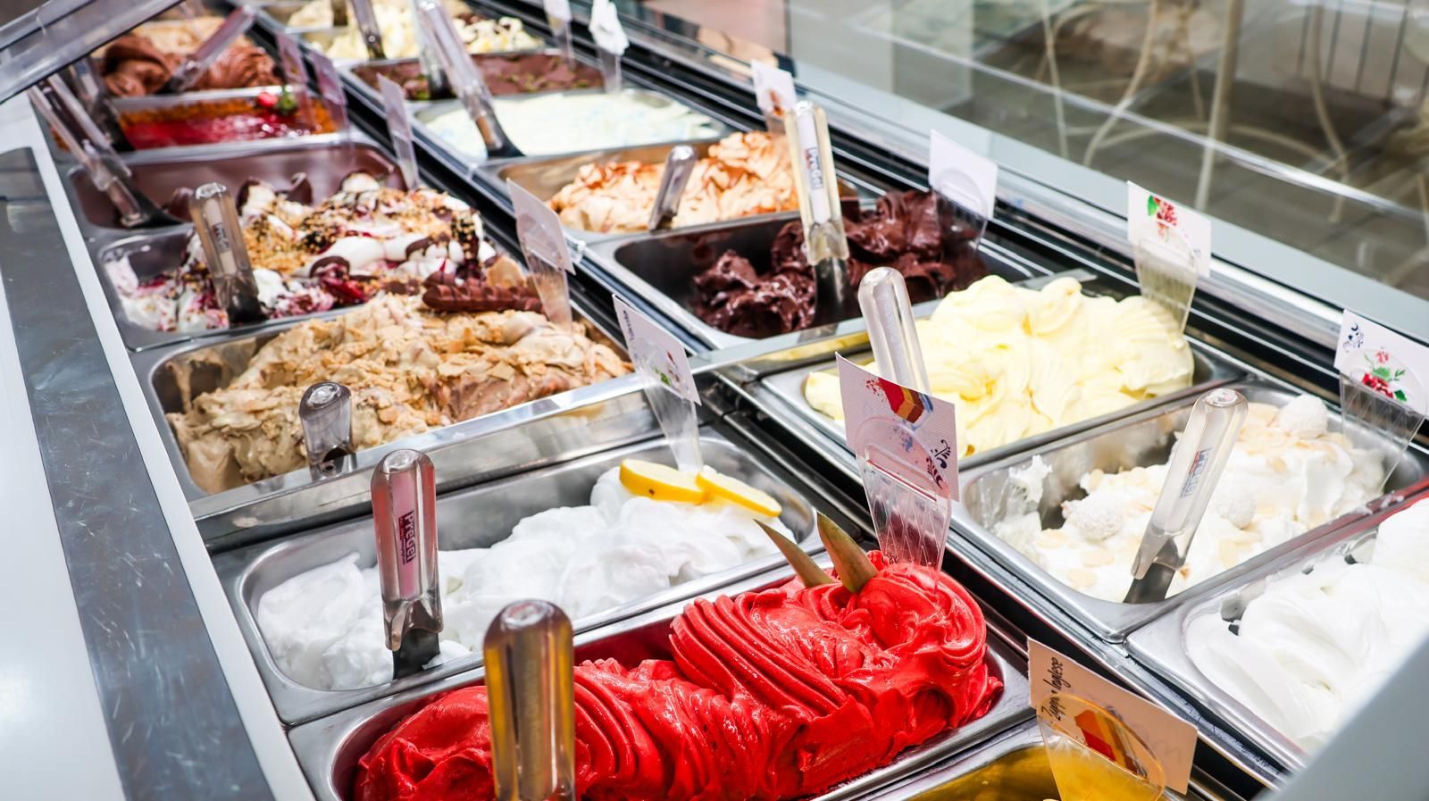 Una vetrina piena di tanti gusti diversi di gelato.
