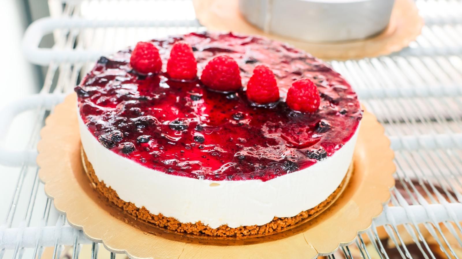 Una cheesecake con lamponi e mirtilli sopra.