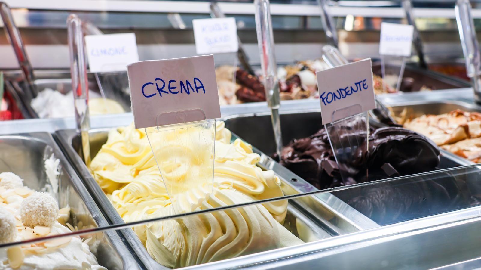 Una vetrina piena di diversi tipi di gelato.