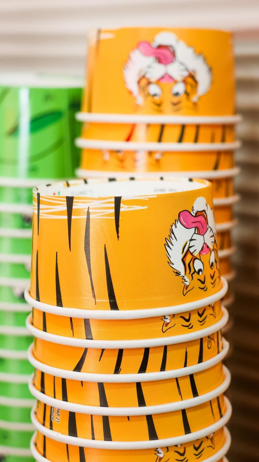 Una pila di bicchieri di carta con una stampa di tigre sopra.