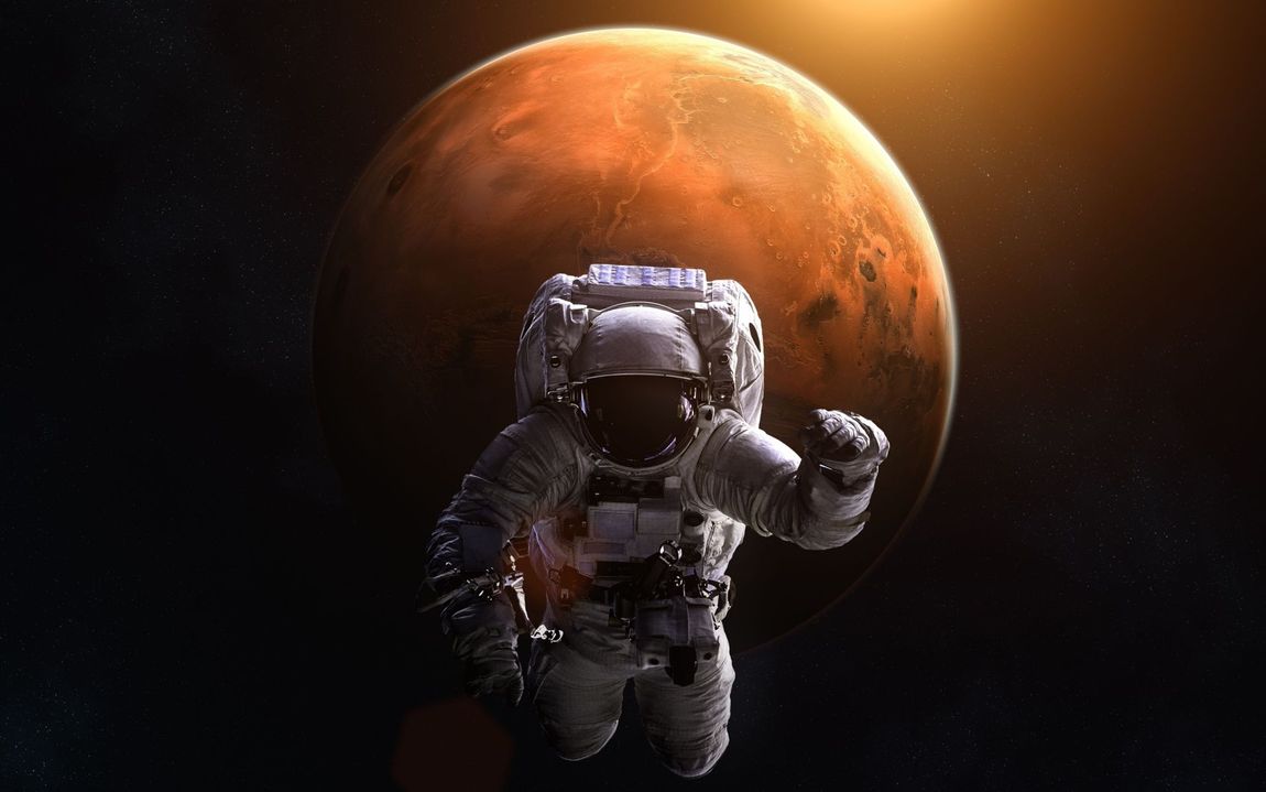 An astronaut is floating in space in front of a planet.