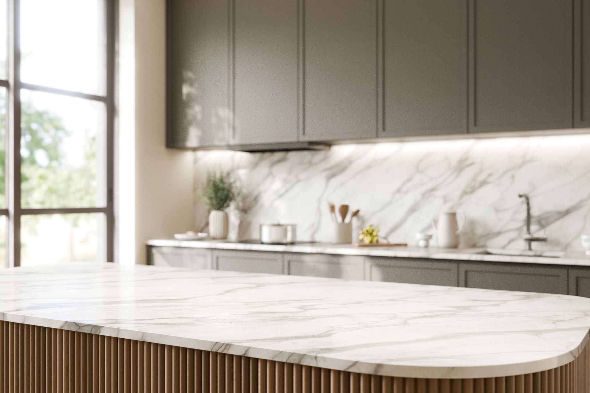 Modern kitchen with marble countertops, dark gray cabinets, and a large window, showcasing a bright, clean design.