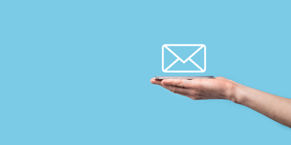 Hand holding a white envelope icon on a blue background