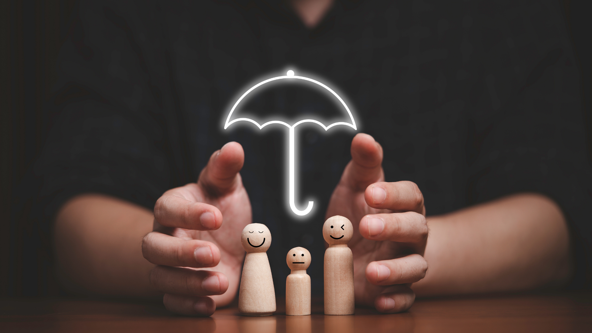 Hands around wooden family figurines under a glowing umbrella symbol