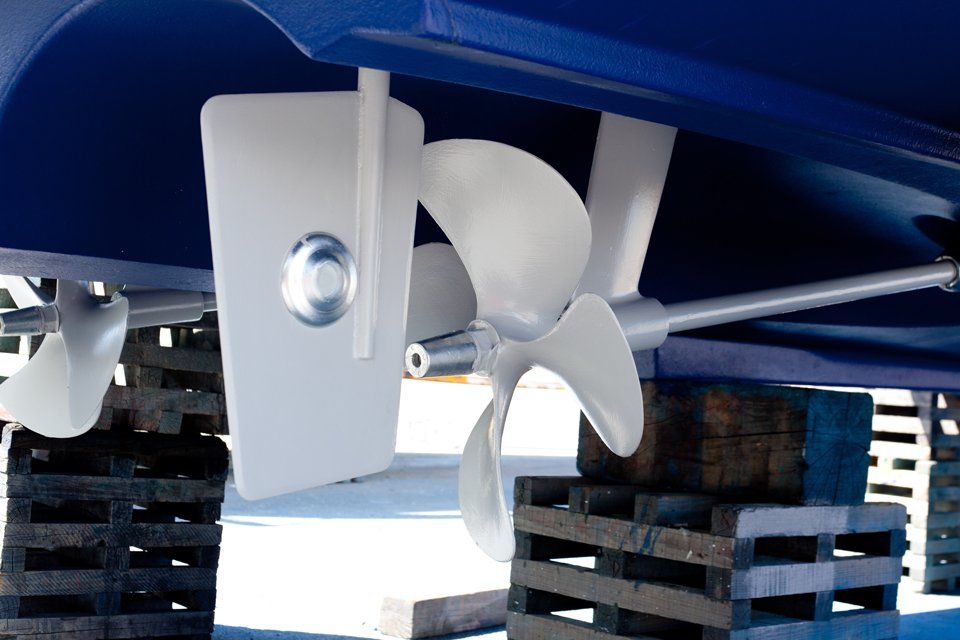 gray painted propeller and steering with zinc anodes in blue hull
