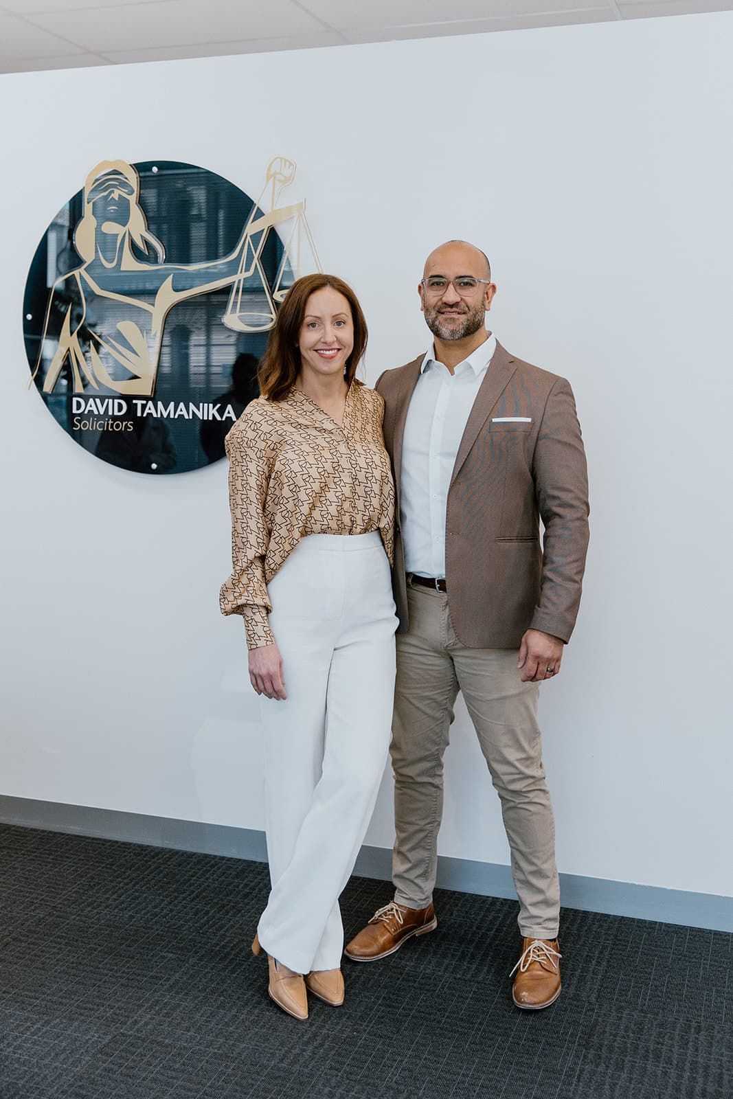  David And Brooke Standing next to each other in front of a Solicitors Sign— David Tamanika Solicitors in Ballarat Central, VIC