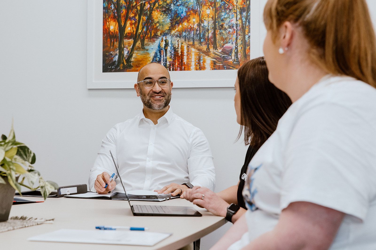 A Group Of People Are Sitting Around A Table With A Laptop — David Tamanika Solicitors in Ballarat Central, VIC