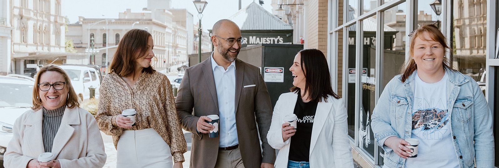 Three Women Are Standing Around A Computer In An Office — David Tamanika Solicitors in Ballarat Central, VIC