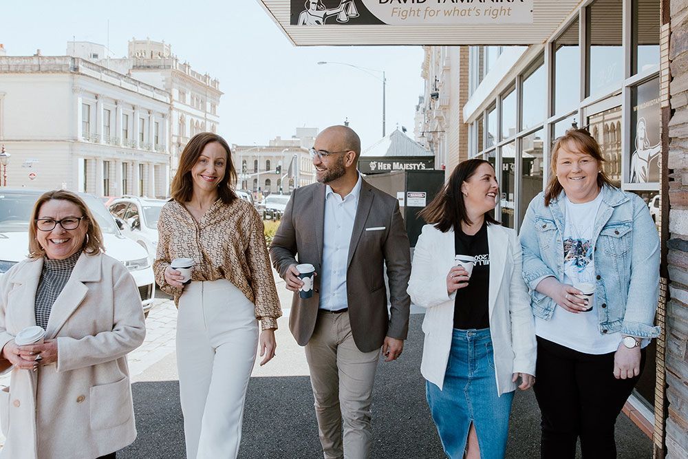 A Group Of People Are Walking Down A City Street — David Tamanika Solicitors in Ballarat Central, VIC