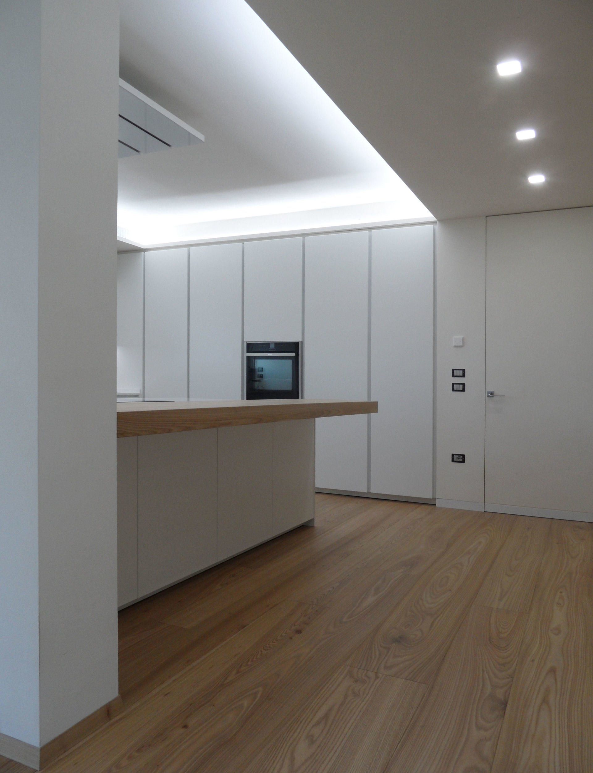 Cucina con isola dal design moderno bianco opaco su misura artigianale con particolari in rovere naturale