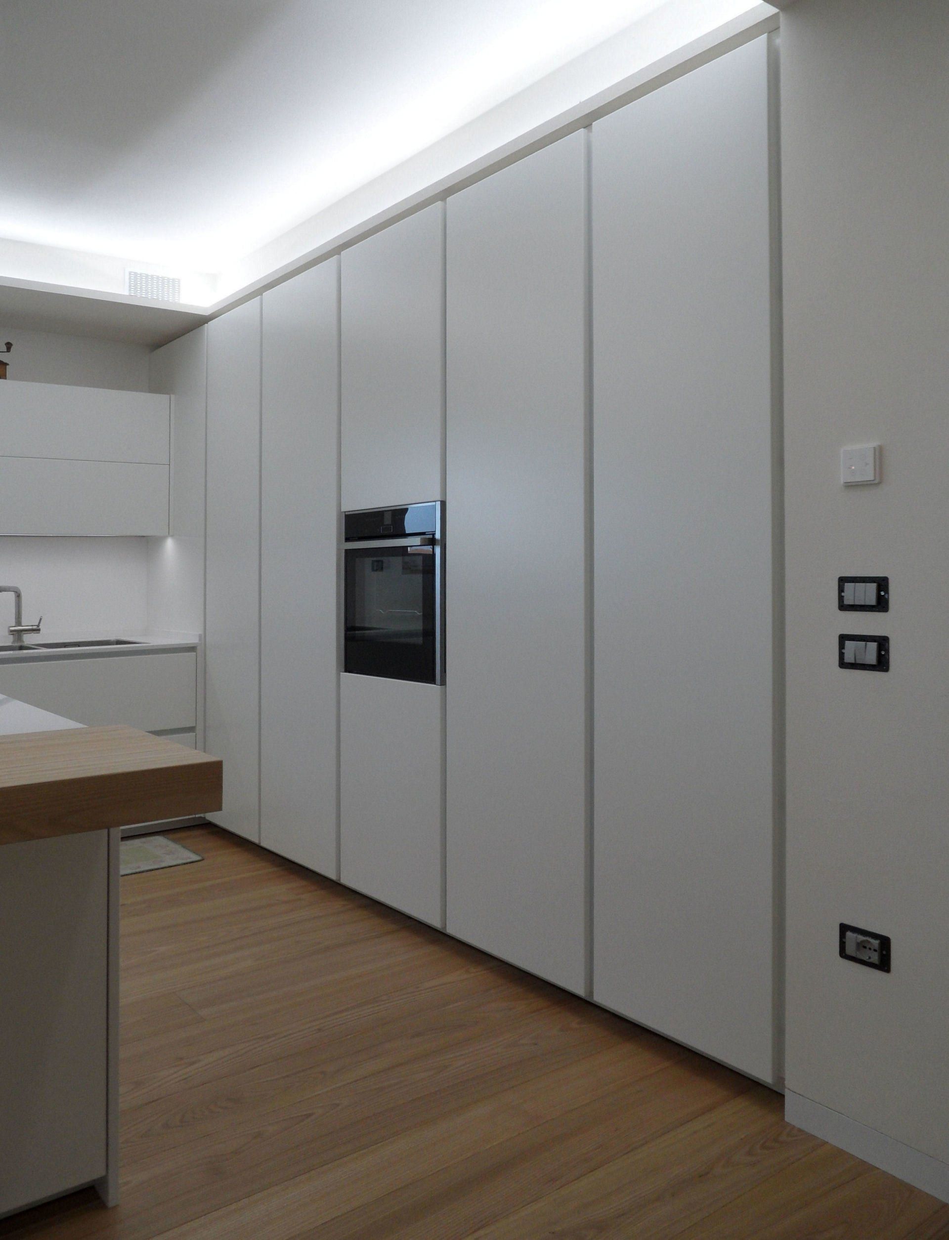 Ambiente cucina con colonne raso muro e ante a soffitto con maniglia gola