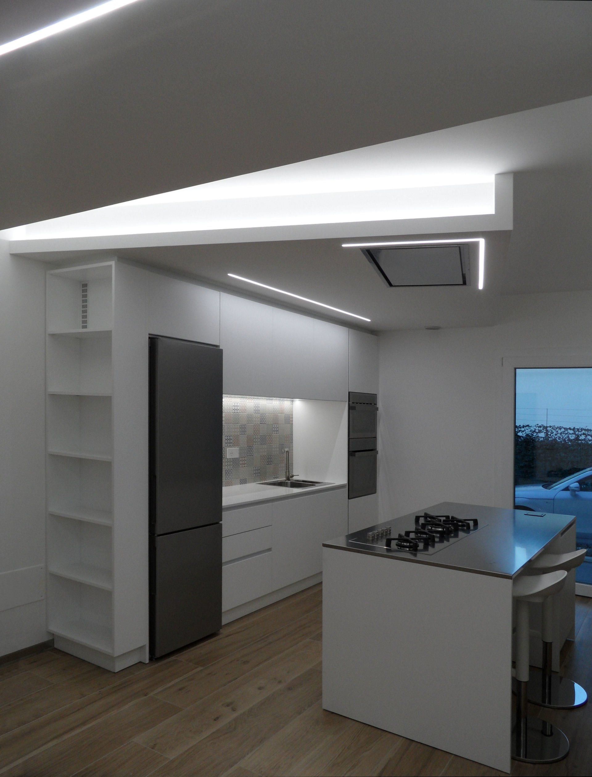 cucina isola con piano in acciaio e cappa incassata a soffitto