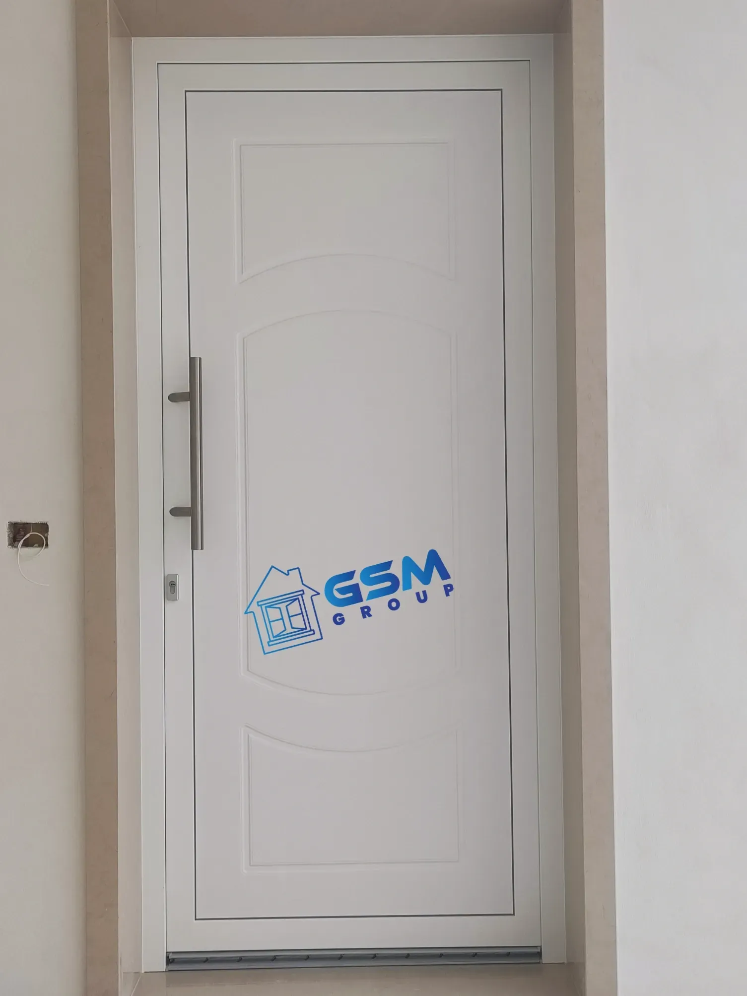 Una porta bianca con maniglia verticale in metallo e logo blu 