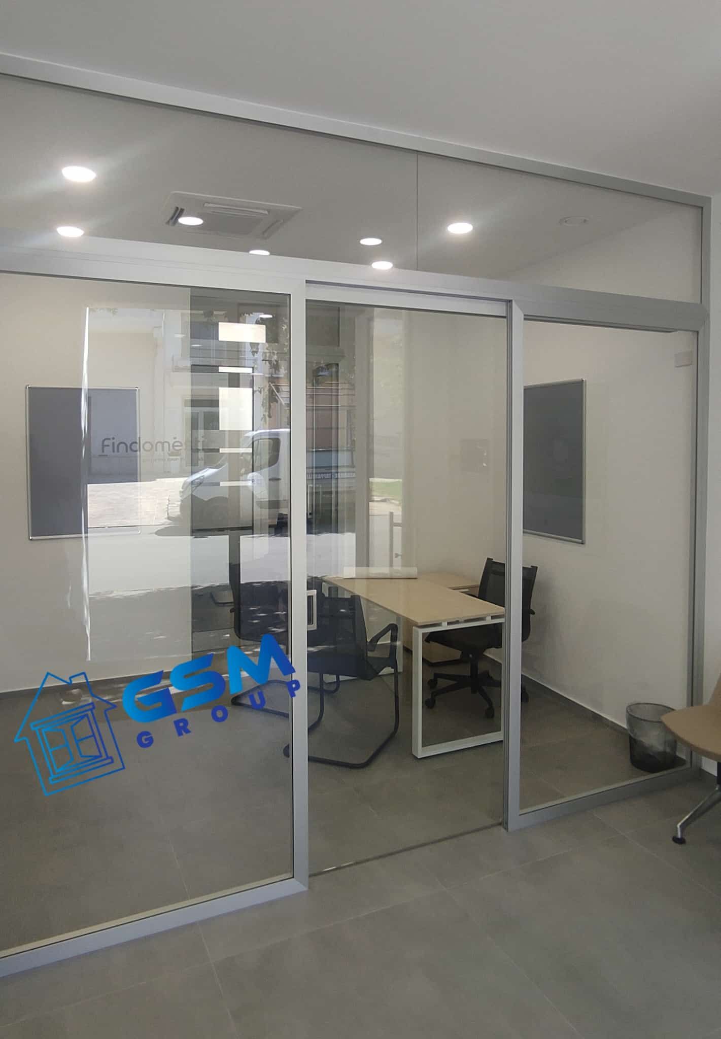 Edificio residenziale a più piani in costruzione con facciata bianca e ringhiere dei balconi verde scuro.