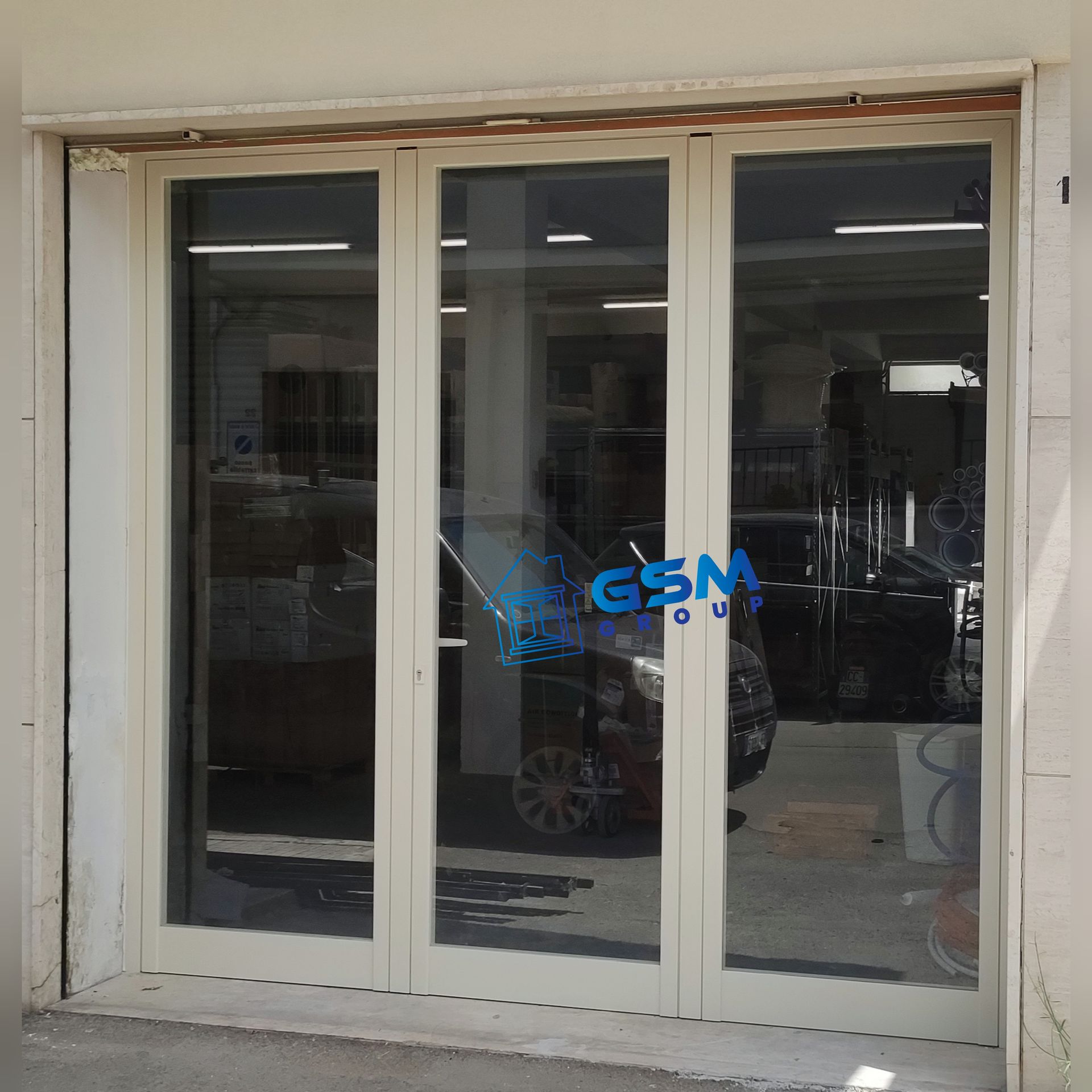 Porta a tre pannelli in vetro con cornice beige e logo blu 