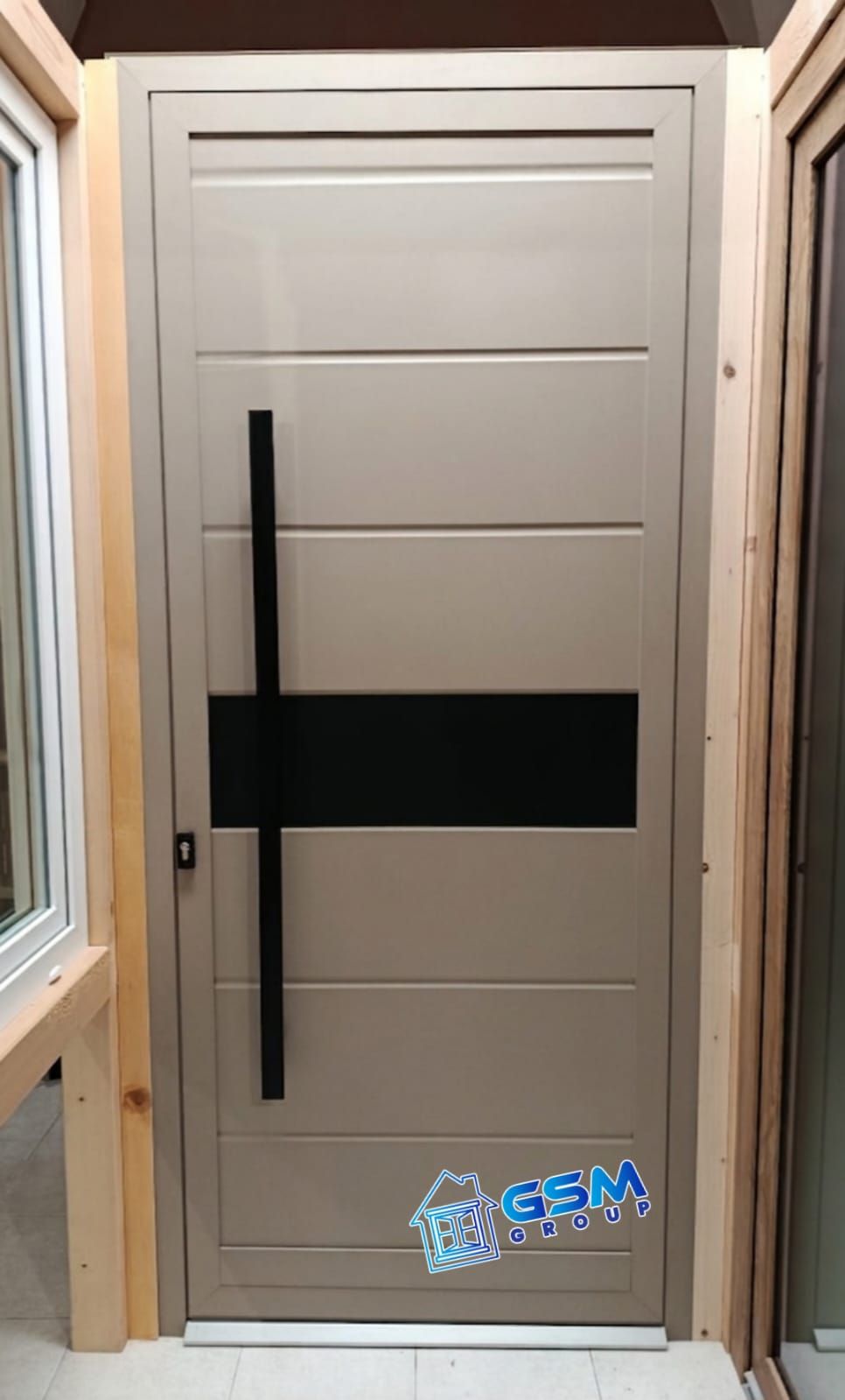 Box in vetro con cornice bianca, porta con maniglione antipanico e appendiabiti, con il logo del Gruppo GSM sul pannello della porta.