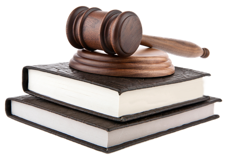 A wooden gavel is sitting on top of a stack of books