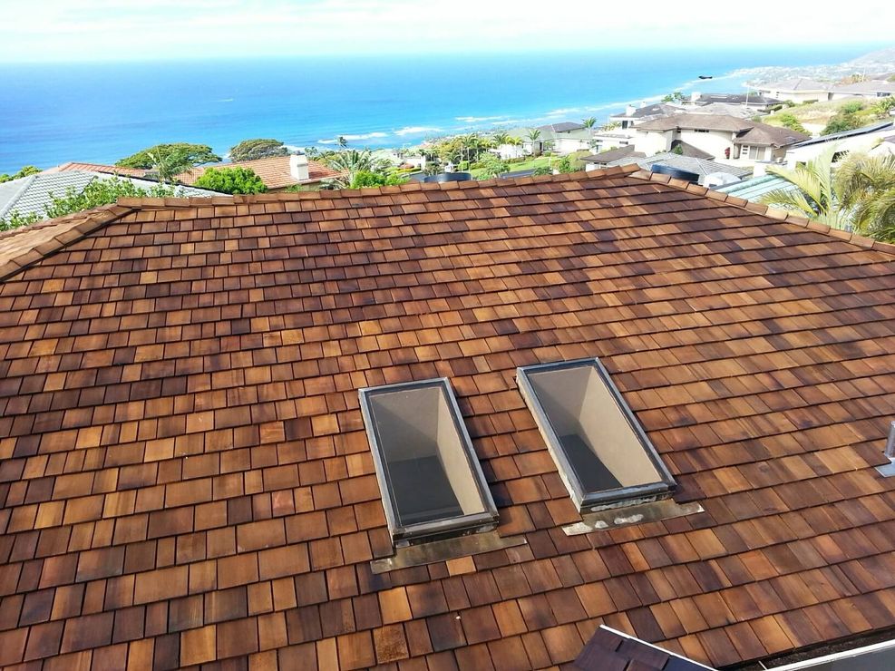 A roof with two skylights and a view of the ocean