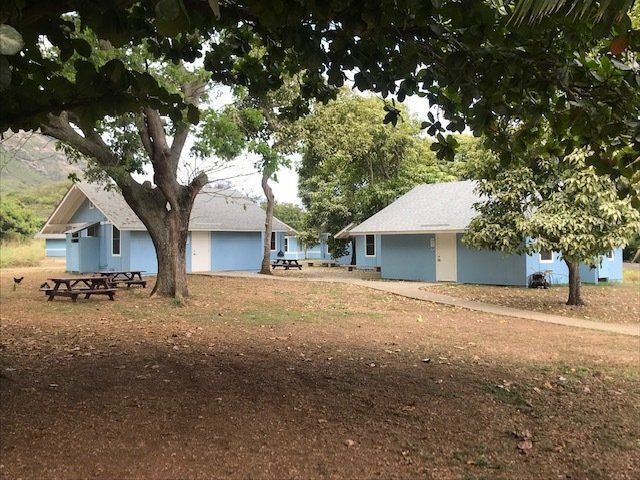 A row of blue houses with picnic tables in front of them