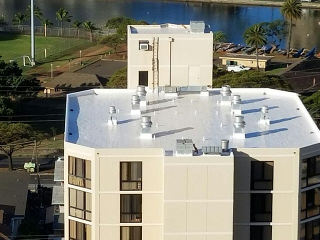 An aerial view of a building with a white roof
