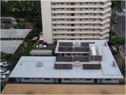 An aerial view of a building with a roof that is covered in shingles.