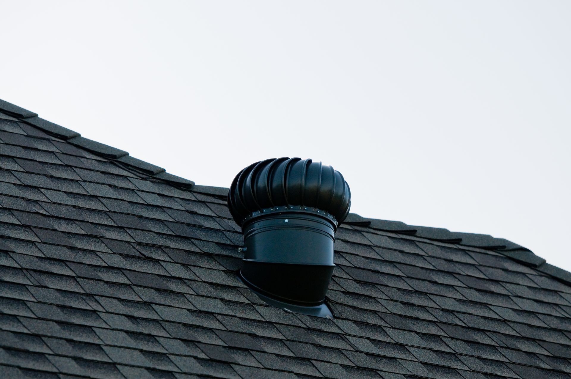 A black roof vent on top of a roof.