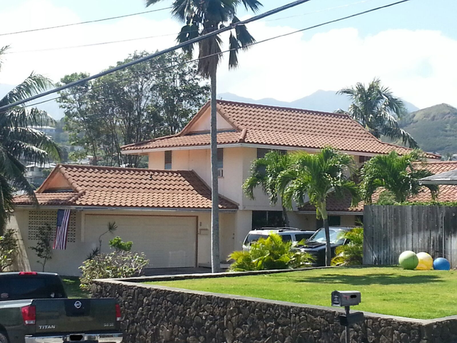 A truck is parked in front of a large house